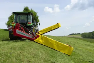 Traktor se žacím strojem Pöttinger Novadisc na louce