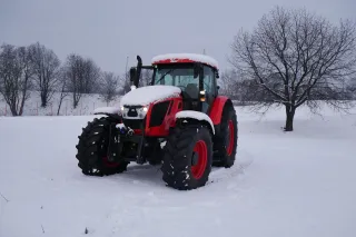 Červený traktor Zetor na zasněženém poli