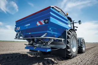 Modrý rozmetací stroj Lemken Polaris na poli