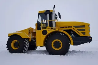 Žlutý historický traktor Kirovets na bílém pozadí