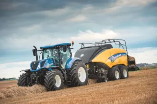 Traktor New Holland s lisem na hranolové balíky na poli