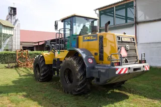 Žlutý kolový nakladač XCMG v zemědělském areálu