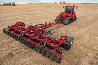 Červený pásový traktor Case IH se strojem na zpracování půdy
