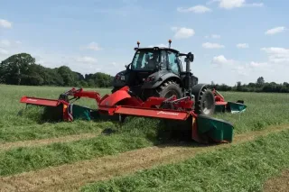 Traktor s žacím strojem Kverneland při sečení louky