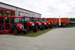 Řada červených traktorů Zetor před novým střediskem ve Slaném