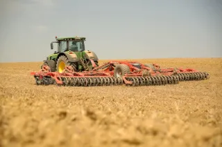 Traktor s diskovým podmítačem Kuhn Optimer při práci na poli
