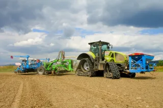 Pásový traktor Claas při setí na poli