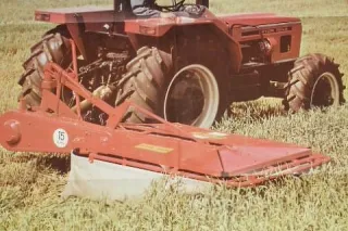 Historický červený traktor se žacím strojem Agrostroj na poli
