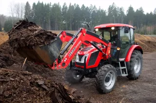 Červený traktor Zetor Proxima s čelním nakladačem při manipulaci s kompostem
