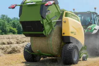 Zelený svinovací lis Krone na poli
