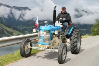 Cestovatel na modrém traktoru Zetor na horské silnici