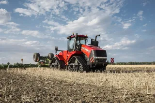 Červený pásový traktor Case IH Quadtrac na poli