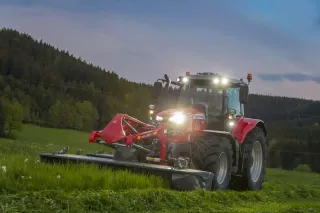 Traktor Massey Ferguson s čelně neseným žacím strojem na louce