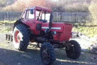Červený traktor Belarus MTZ-82 v zemědělském areálu