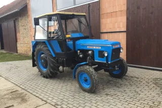 Modrý renovovaný traktor Zetor 6718 u stodoly