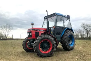Opravený červený traktor Zetor 7245 na louce