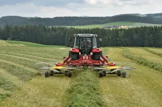 Traktor se žacím strojem na posečené louce