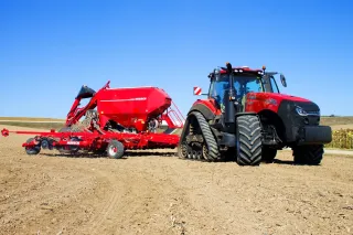 Červený secí stroj za traktorem Case IH Magnum Rowtrac