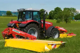 Červený traktor Massey Ferguson se žacím strojem Pöttinger