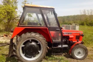 Starší červený traktor Zetor 5511 na zahradě