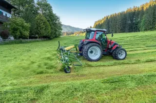 Traktor s obracečem Krone Vendro na louce