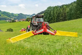Traktor se žacím strojem Pöttinger Novadisc na louce