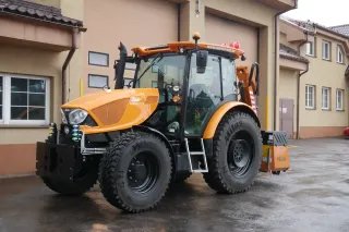Oranžový traktor Zetor Proxima u budovy
