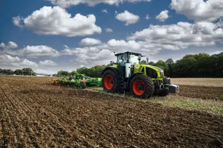 Traktor Claas Axion s nářadím na poli