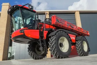 Červený postřikovač Agrifac před budovou