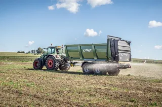 Traktor s rozmetadlem Fliegl na poli