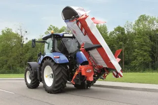 Traktor se žacím strojem Kuhn na louce