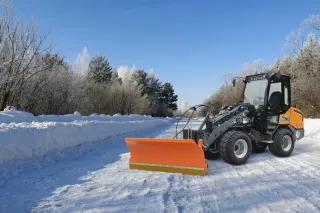 Zasněžená krajina s nakladačem Giant při zimní údržbě