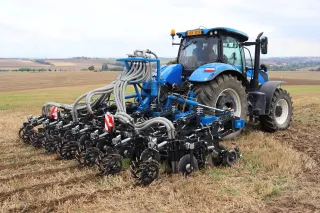 Traktor s technikou pro pásové zpracování půdy na poli