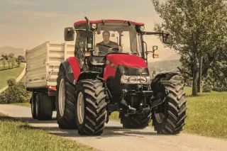 Červený traktor Case IH Farmall C s přívěsem