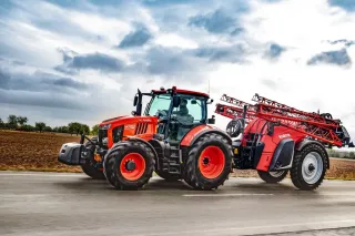 Červený traktor Kubota M7003 na poli