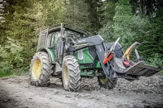 Traktor s lesní ochrannou nástavbou v lese