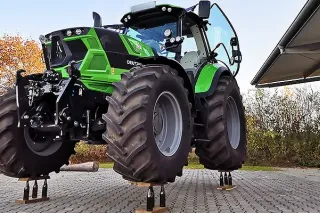 Zelený traktor parkuje na pivních lahvích
