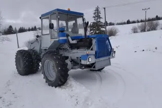 Historický modrobílý traktor ŠT 180N ve sněhu