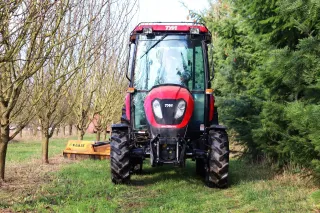 Traktor TYM mezi stromy v ovocném sadu