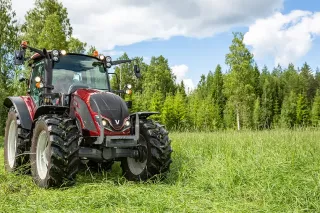 Červený traktor Valtra série A na louce
