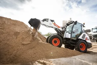 Kompaktní nakladač Bobcat u hromady sypkého materiálu