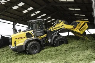 Žlutý kolový nakladač New Holland v hale