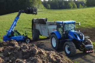 Manipulátor New Holland nakládá hnůj do rozmetadla Pichon