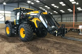 Traktor JCB Fastrac s čelním nakladačem Quicke v hale