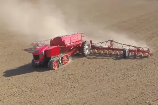 Autonomní pásový secí stroj Horsch s červeným zásobníkem na poli
