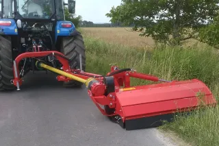 Traktor s červeným bočním mulčovačem Tehnos u krajnice