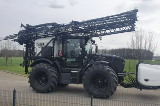 Černý traktor JCB Fastrac s nástavbovým postřikovačem Agrio Tiger