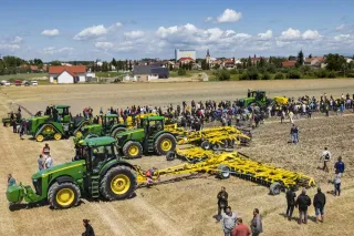 Návštěvníci polního dne prohlížejí traktory a zemědělské stroje
