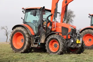 Oranžový traktor Kubota M6 s čelním nakladačem na poli