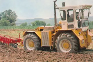 Historický žlutý traktor Rába-180 při práci na poli